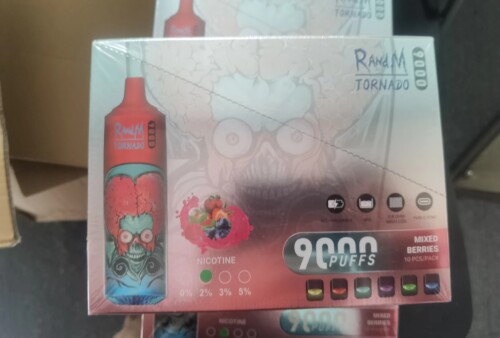 Verpackung für elektronische Zigaretten von RandM Tornado mit farbenfrohem Flaschendesign mit Totenkopf- und Gehirnillustration, Aufschrift „9000 Züge“ und Spezifikationen wie Nikotinstärkeoptionen, Wiederaufladbarkeit und Geschmack nach gemischten Beeren.